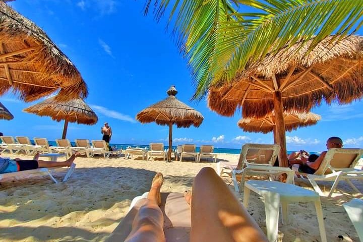 a group of lawn chairs sitting on top of a sandy beach