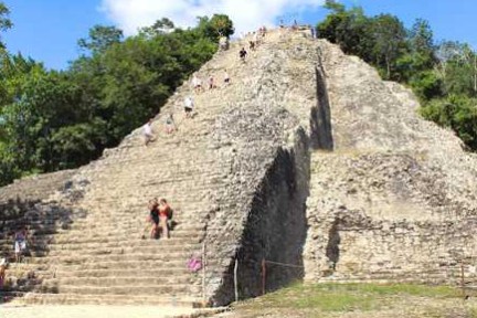 a group of people on a rock with Coba in the background